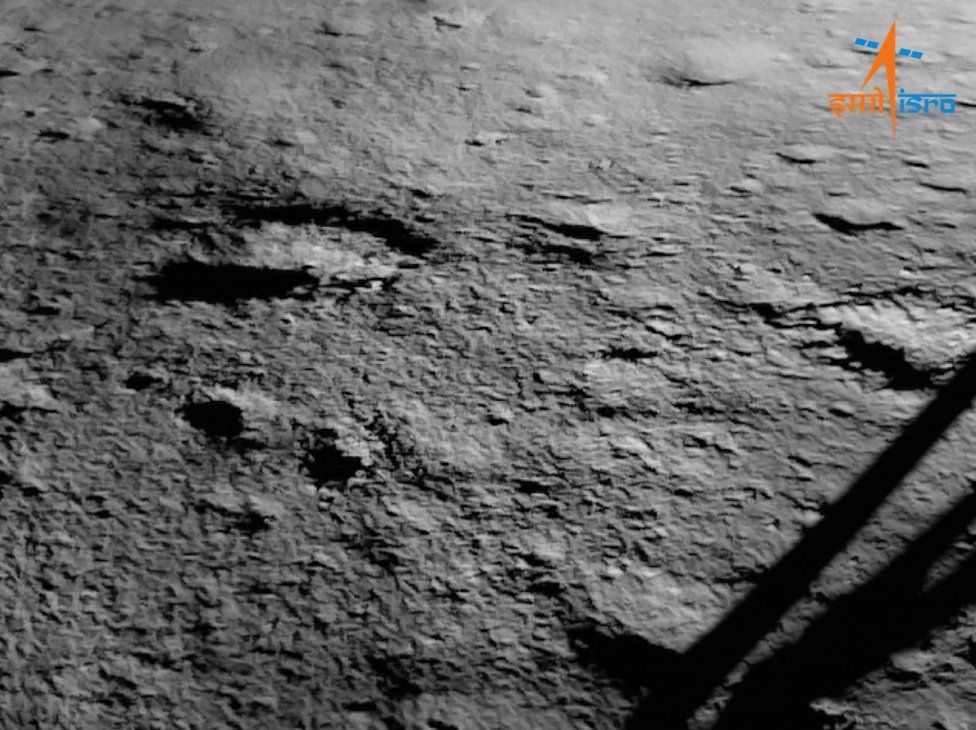 An Isro image of the Chandrayaan-3 landing site taken after touchdown. One of the four legs of the lander is visible on the right